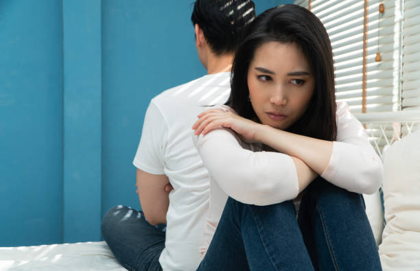 istock Unhappy Couples sitting behind each other on the bed and avoid talking or looking at each other, Cause of relationship problems and having misunderstanding or disagreement. Family problems concept 2024537480