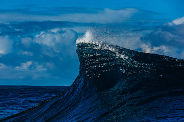 istock Blue wave with curling up in the open ocean over a shallow reef bombora 2024538529