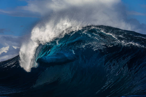 istock Large blue wave with perfect curl breaking in the open ocean over a shallow reef bombora 2024544239