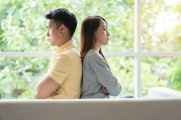 istock Unhappy Couple sitting behind each other on the couch and avoid talking or looking at each other, Cause of relationship problems and having misunderstanding or disagreement. Family problems concept 2024548499