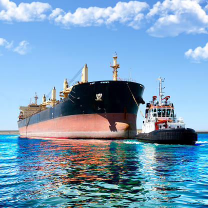 Tugboat helping ship in the harbor