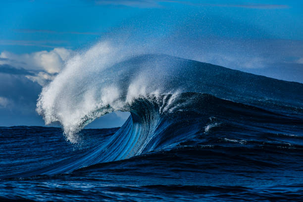 istock Large blue wave with perfect curl breaking in the open ocean over a shallow reef bombora 2024559419