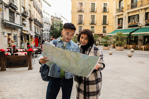 young couple on vacation are outing in the city looking at the map