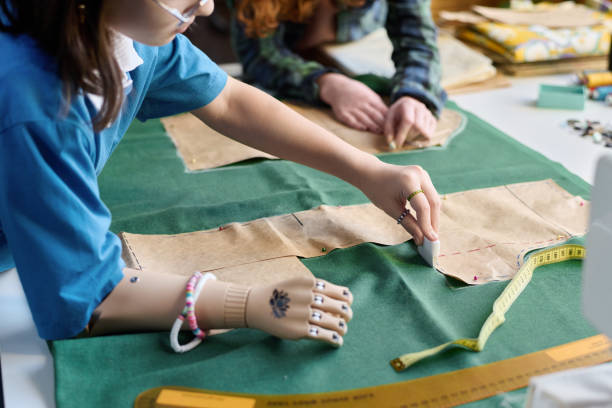 istock Girl with Prosthetic Arm Making Clothing 2024599234