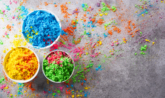 Happy Holi decoration, the indian festival.Top view of colorful holi powder on dark stone background.