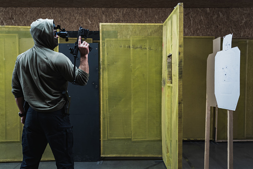 Tactical shooting from modern firearms at a shooting range. A man holds a carbine pistol in his hand. High quality photo