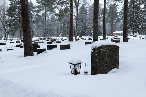 grave stones at cemetery covered in snow