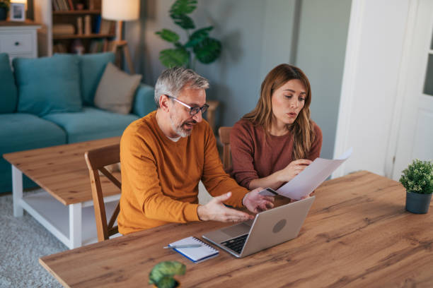 istock Frustrated couple checking bills at home using laptop 2024632643