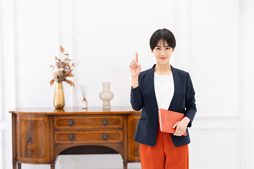 Young Japanese businesswoman standing at the entrance of the office