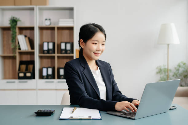 istock Young beautiful woman typing on tablet and laptop while sitting at the working white table 2024650090