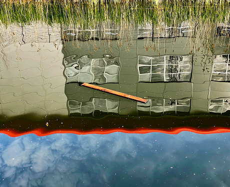 Plank of wood floating in the River Lea Navigation at Ponders End in Hertford. May 2022