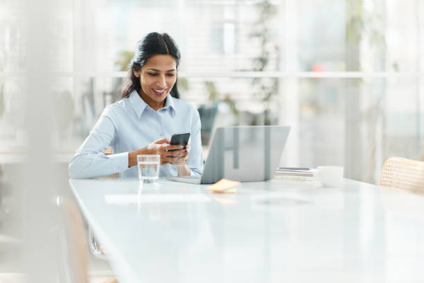 istock Happy Indian female entrepreneur using cell phone in the office. 2024672189