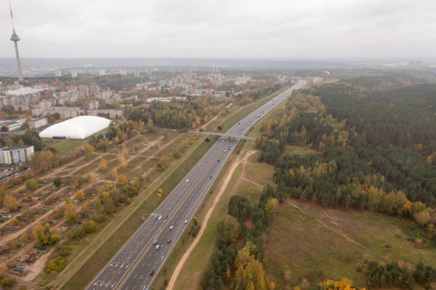 drone photography of multiple lane highway near a city during autumn day - multiple lane highway highway car field imagens e fotografias de stock