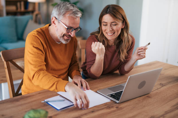 istock Shot of a gentle couple using a laptop while doing their budget work in their dining room at home 2024679516