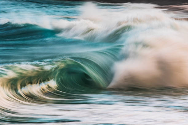 istock Slow shutter blur of smooth wave breaking on the beach with ambient soft light 2024680354