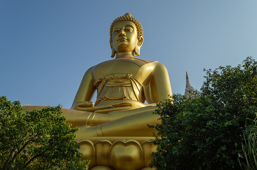 The big golden Buddha statue outdoors and the blue sky looked very beautiful.