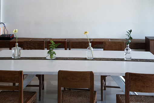 Large group of white tables and chairs for a formal event, such as a wedding reception or anniversary party.