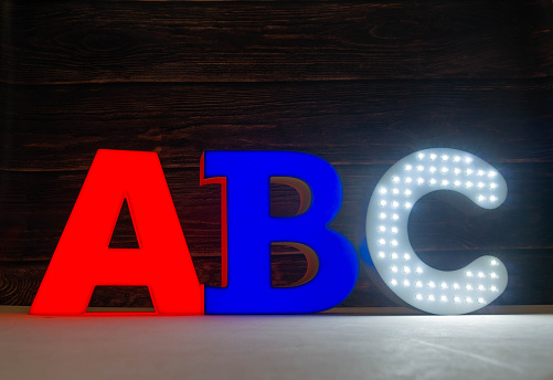 The light letters A, B and C are part of an advertising sign. Red,blue and white.