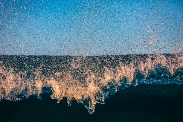 Close up texture of a breaking wave in rich golden light. Photographed in Western Australia.