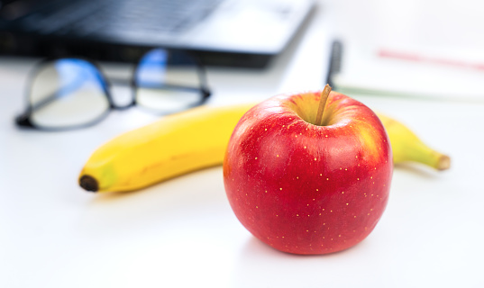 The concept of a healthy food at work. Fruits on the desktop. Close-up. Selective focus.
