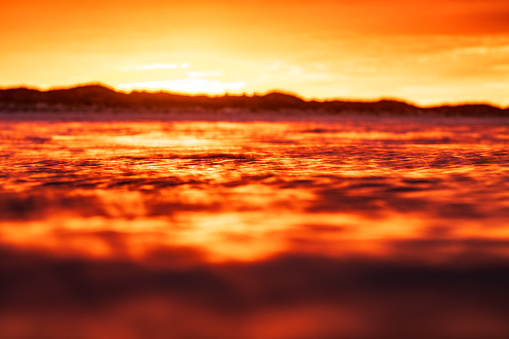 Blurred focus on rippled golden water surface texture.