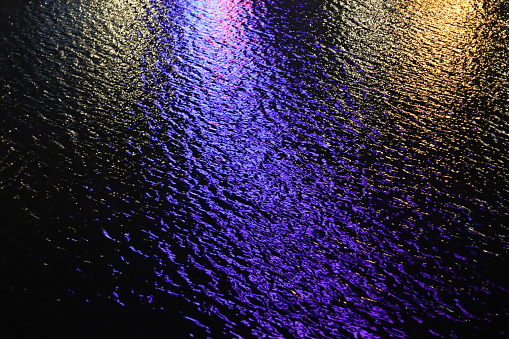 Purple lights glittering in water at night