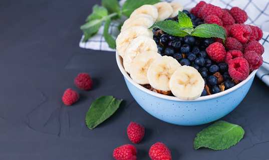 A healthy breakfast with fresh berries, fruits and oatmeal on a dark background. The concept of a healthy breakfast in the morning. ?lose-up. Copy space.