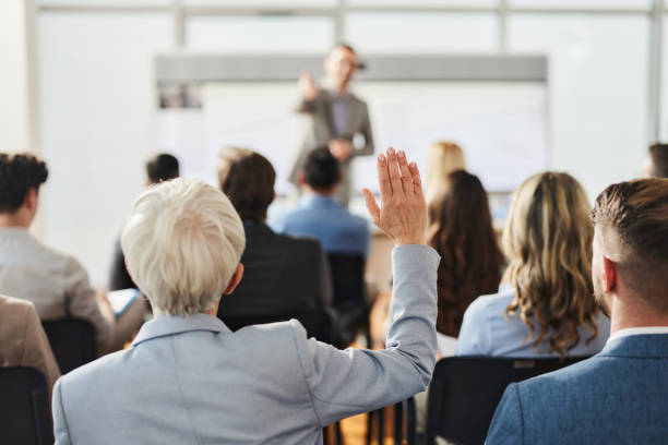 istock Rear view of entrepreneur asking a question on presentation in the office. 2024729380