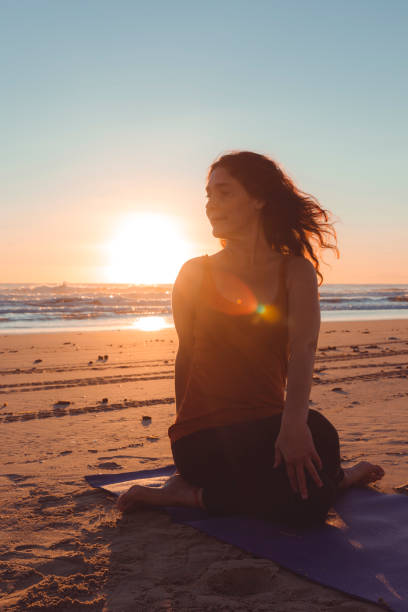 istock silhouette of a woman on the beach practicing a stretching exercise at sunset 2024730159