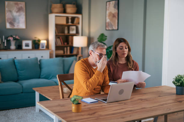 istock Frustrated couple checking bills at home using laptop 2024732819