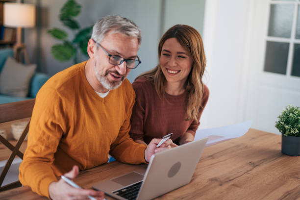 istock Shot of a gentle couple using a laptop while doing their budget work in their dining room at home 2024739120