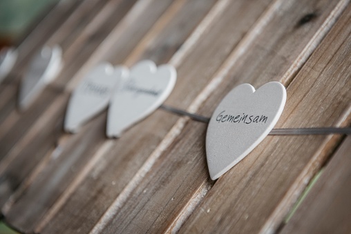 A closeup of hearts on strings decoration for wedding with the German word 
