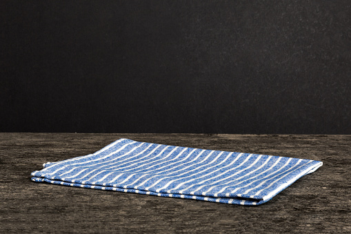 top view with blue kitchen napkin isolated on table background. Folded cloth for mockup with copy space, Flat lay. Minimal style.