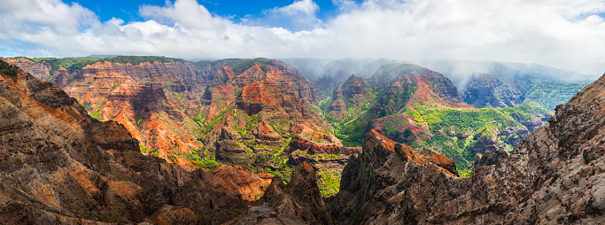 Panorama of rain and mist moving over majestic and colorful mountains and valleys in Hawaii. Photographed in Waimea Canyon, Kauai, Hawaii.