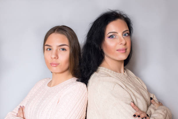 A woman with black hair next to a young girl. Mom is next to her daughter.