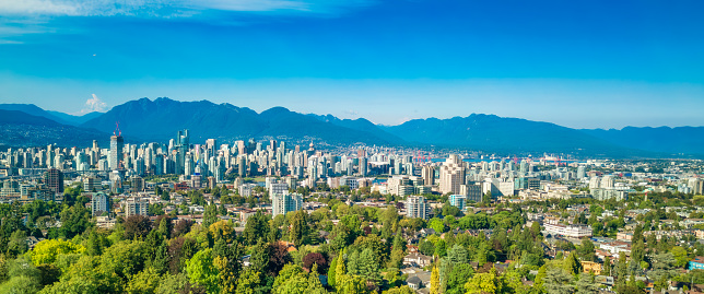 An aerial view of the skyline of Vancouver under a clear blue sky.