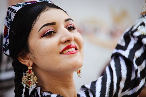 Bukhara, Uzbekistan - June 19, 2023: A woman wearing a black and white striped shirt and statement earrings, standing confidently. She exudes style and grace in her fashionable attire.