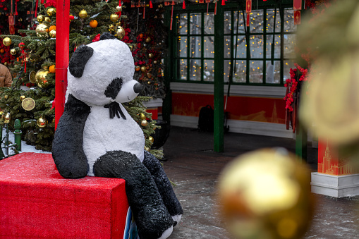 Sad panda and decorated Christmas tree at chinese new year celebration in Moscow.