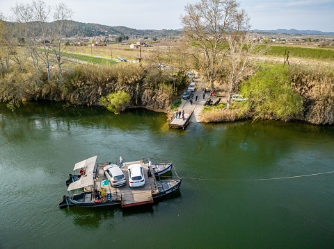 March 25, 2023 - Miravet, Spain: Aerial view of the small car ferry named Pas de Barca that carries 2 cars across the river Ebro outside Miravet village