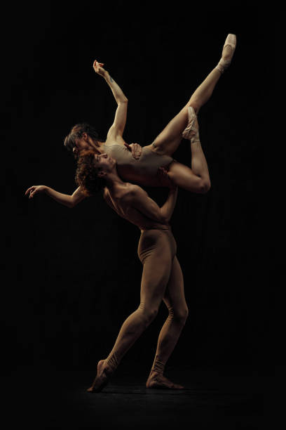 istock Young man and woman, ballet dancers making creative, beautiful performance, dancing against black background. 2024823202