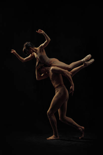 istock Young man and woman, ballet dancers making creative, beautiful performance, dancing against black background. 2024823207
