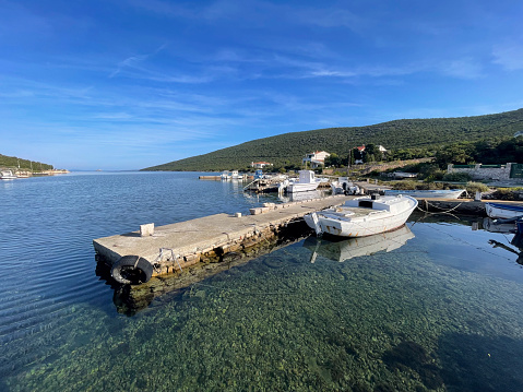 Scenic view of Adriatic sea with boat moored at jetty during sunny day.