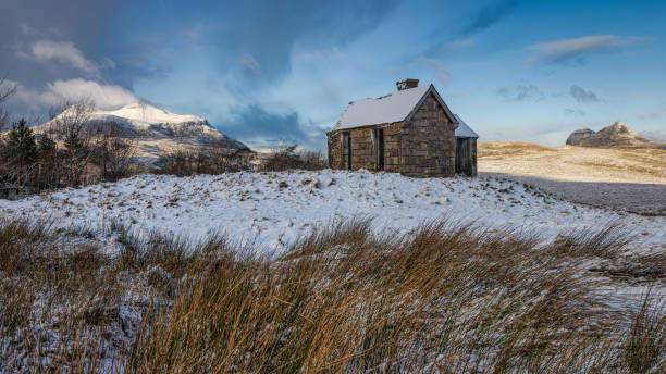 A winters day in the north of Scotland with the Elphin Bothy flanked by  Cul Mor on the left and Suilven to the right.
