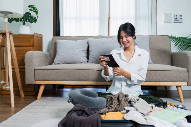 istock Young woman check baggage lists on notebook to prepare for traveling trip 2024958260