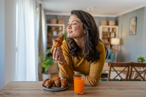 Photo of beautiful woman enjoying the smell of her breakfast