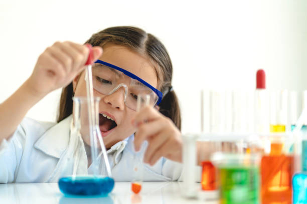 istock Cute little girl student child learning research and doing a chemical experiment while making analyzing and mixing liquid in glass at science class on the table.Education and science concept 2025054917
