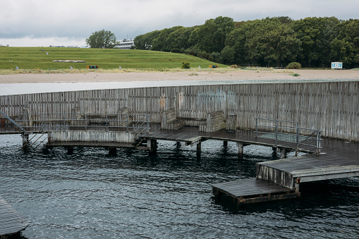 Kastrup Sobad, Copenhagen, Denmark, A round structure representing a swimming pool in the sea, which can be accessed via a walkway leading from the beach.