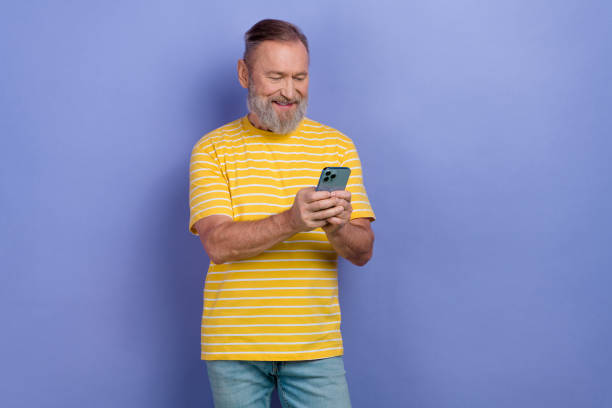 istock Portrait of nice aged man use smart phone texting eshopping empty space isolated on purple color background 2025081189