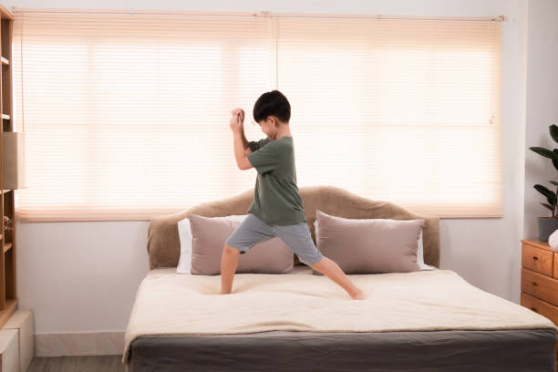 istock Happy asian elementary school boy jumping and dancing on bed, kid jumped and stomped around joyfully alone in bedroom without feeling tired. little boy have fun on the weekend. healthy child concept. 2025090487