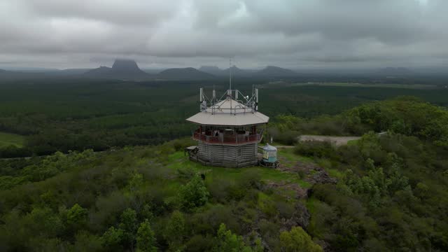 Panoramic drone view of the Wild Horse Mountain scenic lookout and fire tower with views of the Glass House Mountain Range.